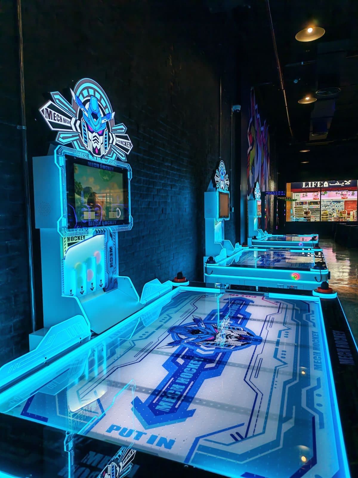 Neon-lit air hockey tables in a game zone