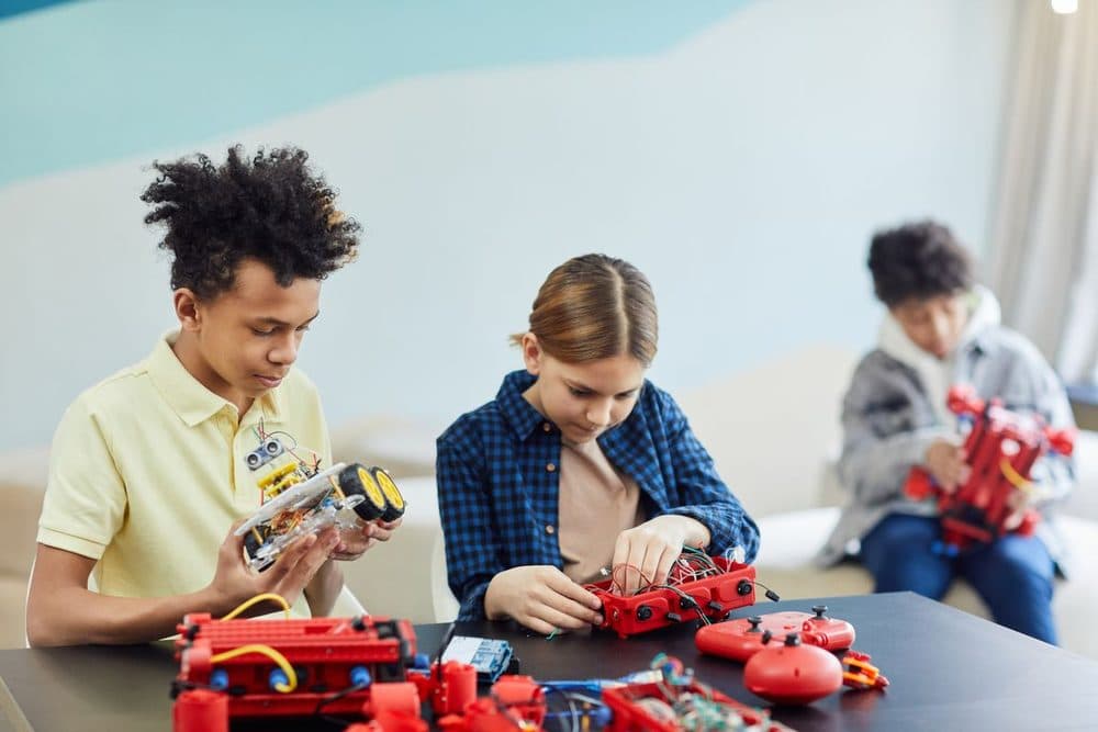 Students building red robotics kits